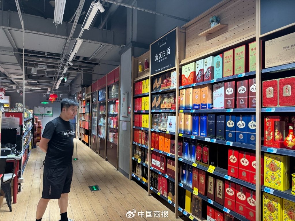 图为消费者在超市选购白酒。